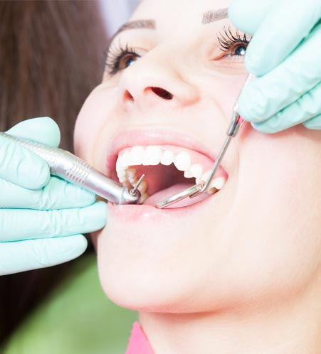 Dentist examining woman's teeth