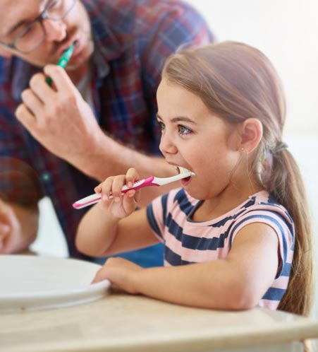 Family brushing their teeth together