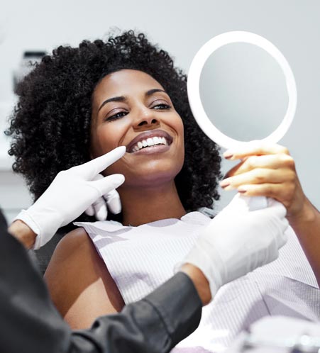 Woman admiring new smile in a mirror