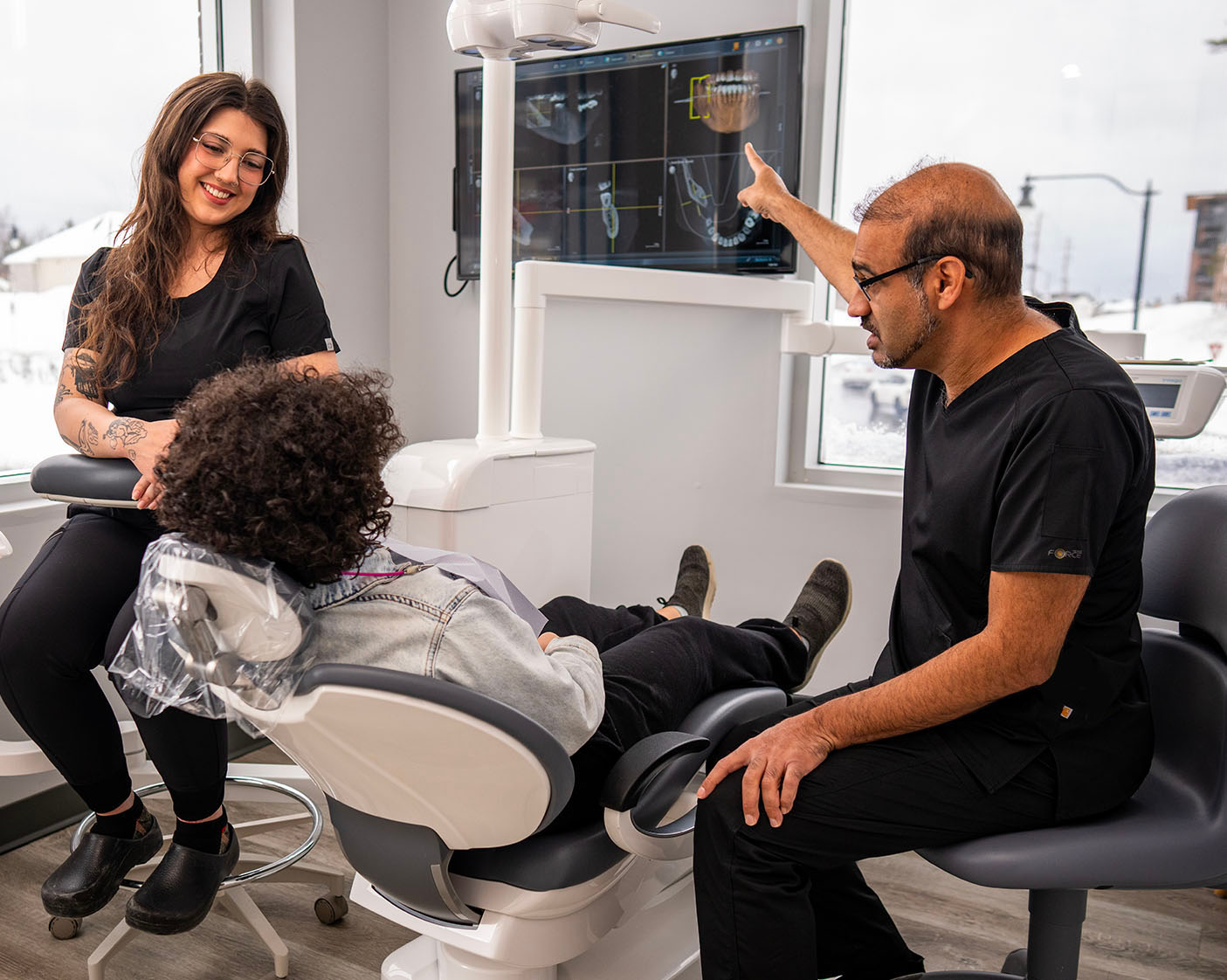 Dentist and hygienist treating patient